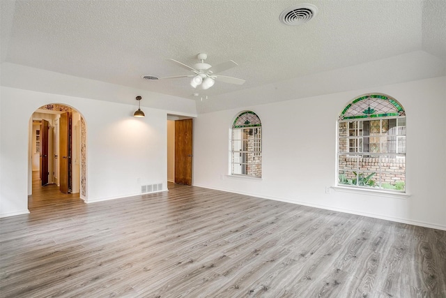 empty room featuring a textured ceiling, light hardwood / wood-style flooring, and ceiling fan