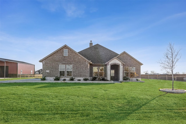 view of front facade featuring an outdoor structure and a front lawn