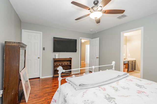 bedroom featuring connected bathroom, dark hardwood / wood-style floors, and ceiling fan