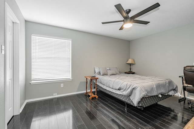 bedroom featuring multiple windows, dark wood-type flooring, and ceiling fan