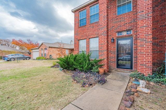 property entrance with a garage and a lawn