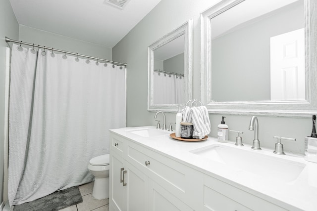 bathroom with tile patterned flooring, vanity, and toilet