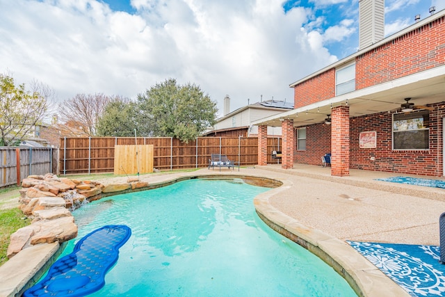 view of swimming pool with ceiling fan, pool water feature, and a patio