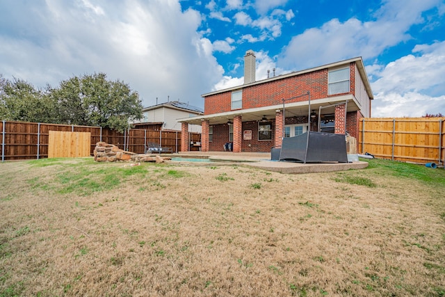 rear view of house with ceiling fan, a yard, and a patio