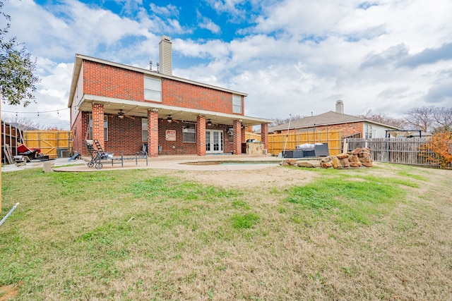 back of house with a lawn, ceiling fan, a patio, and a hot tub