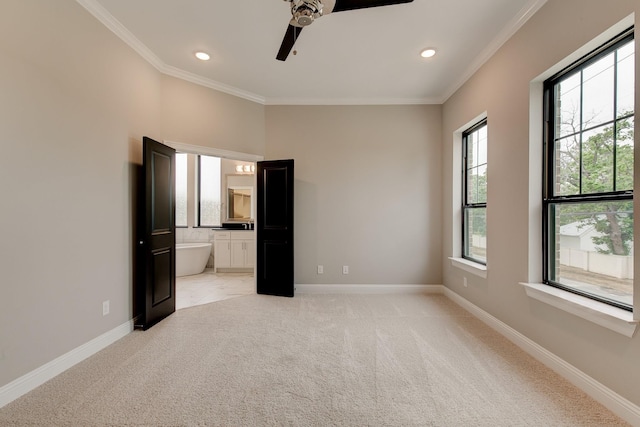 unfurnished bedroom featuring ceiling fan, light colored carpet, ornamental molding, and connected bathroom