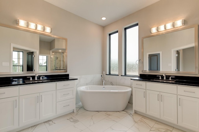 bathroom with vanity, independent shower and bath, and tile walls