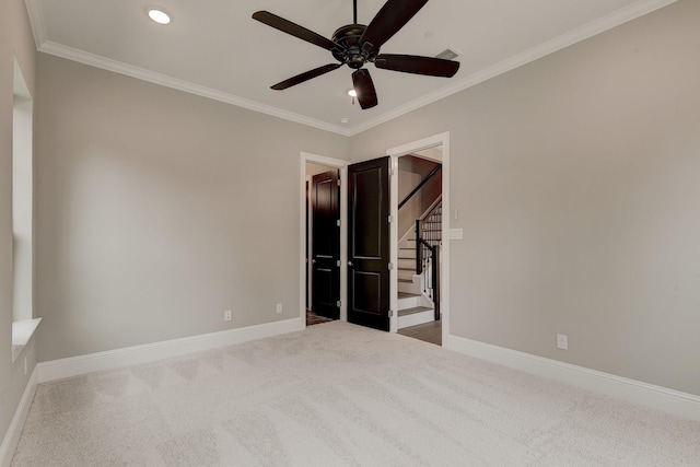 interior space featuring ornamental molding, light colored carpet, and ceiling fan