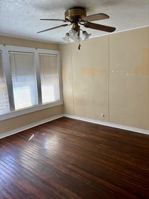 empty room with ceiling fan, crown molding, a textured ceiling, and dark hardwood / wood-style flooring