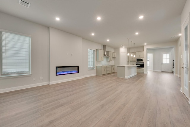 unfurnished living room featuring light hardwood / wood-style flooring and sink