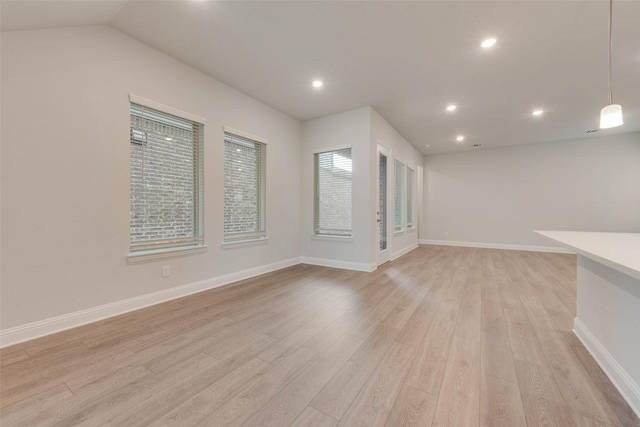 unfurnished living room with light wood-type flooring and lofted ceiling