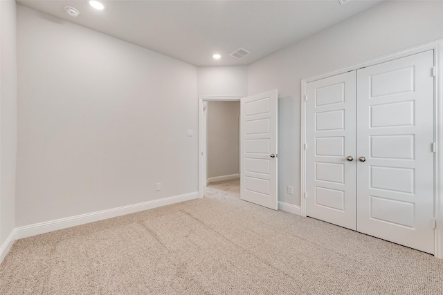 unfurnished bedroom featuring carpet flooring and a closet