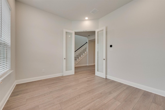 unfurnished room featuring light hardwood / wood-style floors and french doors