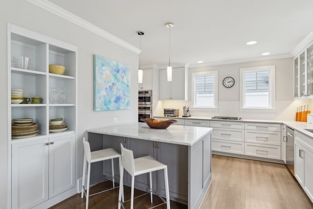 kitchen featuring light stone counters, a kitchen breakfast bar, tasteful backsplash, and white cabinets