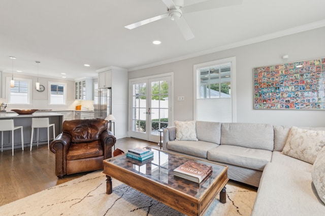 living room with hardwood / wood-style floors, ornamental molding, and ceiling fan