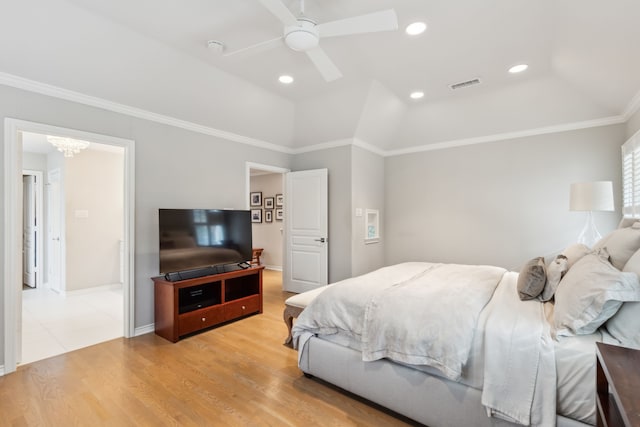 bedroom featuring lofted ceiling, crown molding, a tray ceiling, light hardwood / wood-style floors, and ceiling fan with notable chandelier