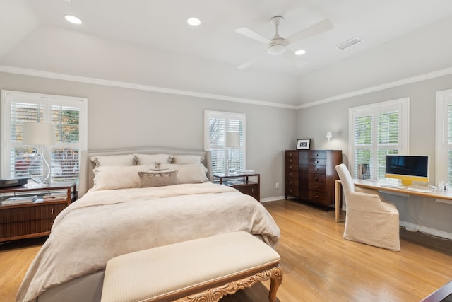 bedroom with a raised ceiling, ornamental molding, ceiling fan, and light hardwood / wood-style floors