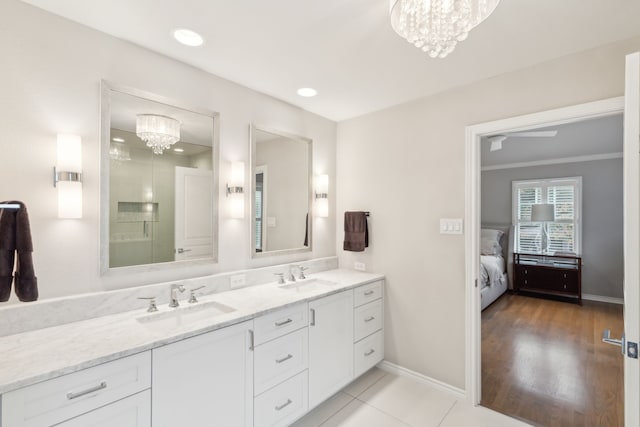 bathroom with vanity, crown molding, a notable chandelier, and tile patterned floors