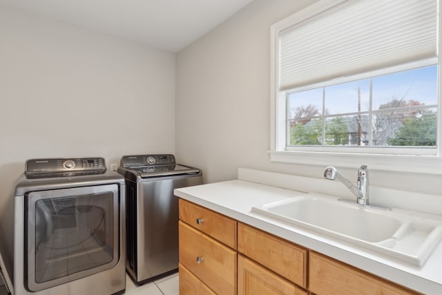 laundry area featuring sink, light tile patterned floors, cabinets, and washer and dryer