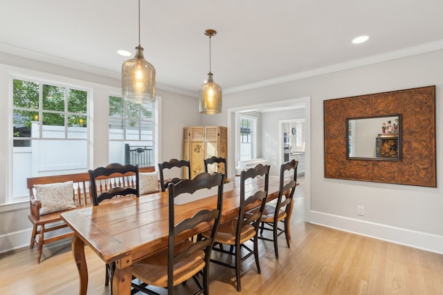 dining area featuring ornamental molding and light hardwood / wood-style floors