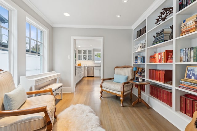 sitting room featuring crown molding and light hardwood / wood-style flooring