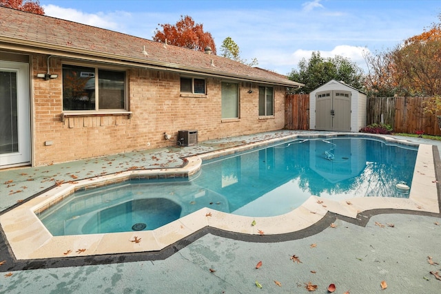 view of swimming pool with a hot tub, central AC unit, and a storage shed