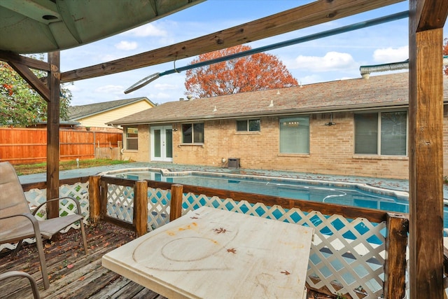 wooden deck featuring a fenced in pool and french doors