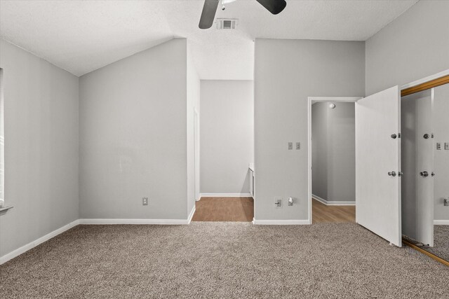 unfurnished bedroom with carpet flooring, ceiling fan, lofted ceiling, a textured ceiling, and a closet