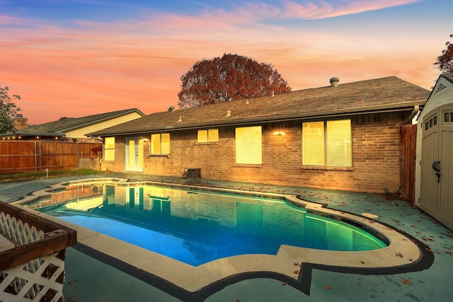 pool at dusk featuring a patio area