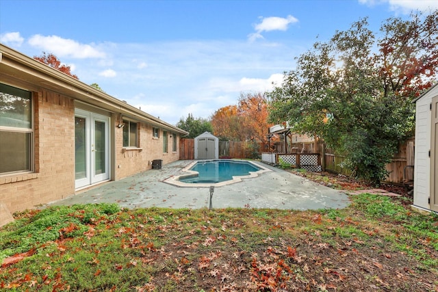 view of pool with a patio and a storage shed