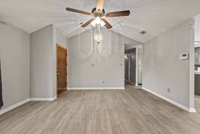 spare room with vaulted ceiling, ceiling fan, light hardwood / wood-style floors, and a textured ceiling