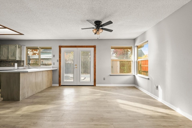 interior space featuring french doors, a textured ceiling, light hardwood / wood-style floors, and ceiling fan