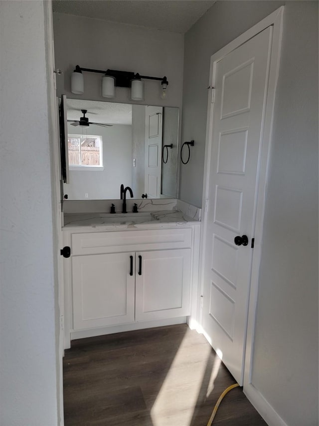 bathroom with hardwood / wood-style floors, ceiling fan, and vanity