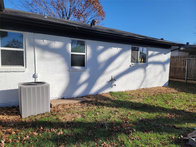 view of home's exterior featuring central air condition unit and a yard