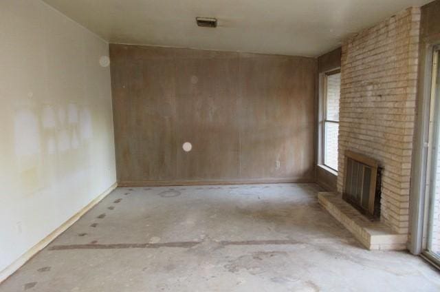 spare room featuring a brick fireplace