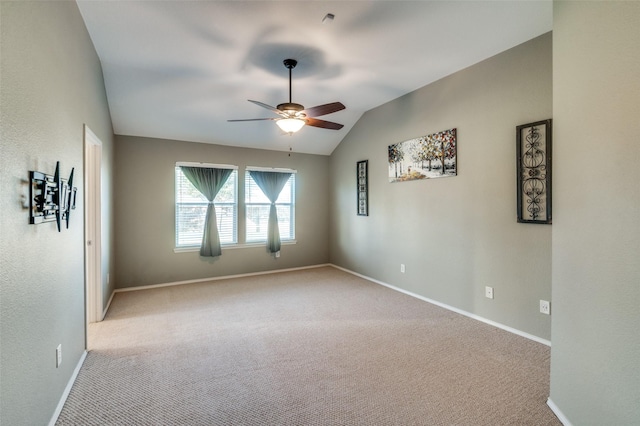 empty room featuring ceiling fan, light colored carpet, and lofted ceiling