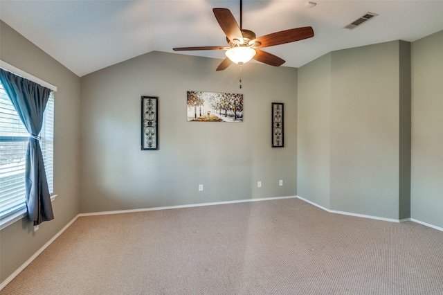 carpeted spare room featuring ceiling fan and lofted ceiling