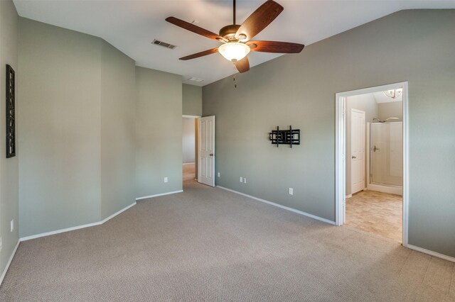 unfurnished bedroom featuring light carpet, ceiling fan, ensuite bathroom, and vaulted ceiling