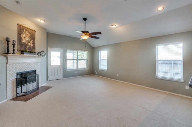 unfurnished living room featuring a tiled fireplace, light carpet, ceiling fan, and lofted ceiling