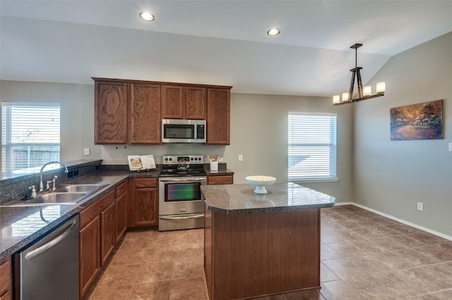 kitchen with lofted ceiling, sink, decorative light fixtures, light tile patterned flooring, and stainless steel appliances