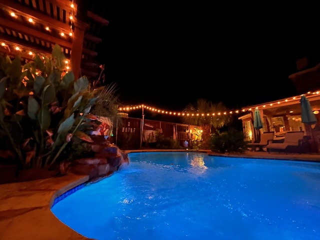 view of pool at twilight