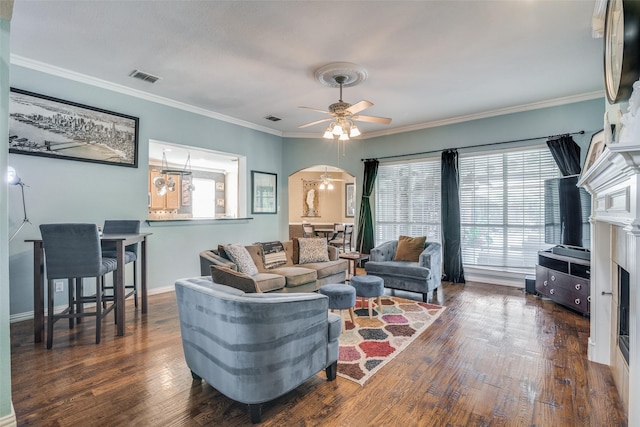 living room featuring ceiling fan, dark hardwood / wood-style flooring, and ornamental molding