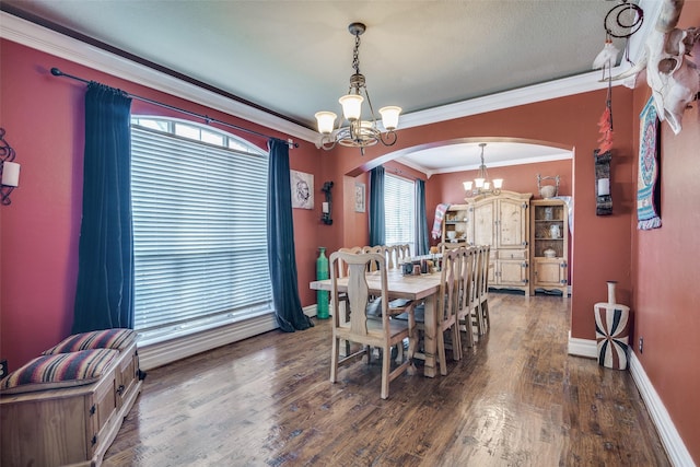 dining area with crown molding, plenty of natural light, dark wood-type flooring, and an inviting chandelier