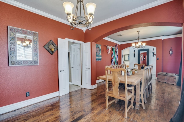 dining area with dark hardwood / wood-style flooring, ornamental molding, and an inviting chandelier