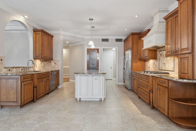 kitchen featuring pendant lighting, custom exhaust hood, a center island, sink, and appliances with stainless steel finishes