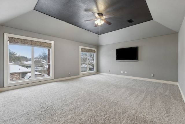 carpeted empty room with ceiling fan and a tray ceiling