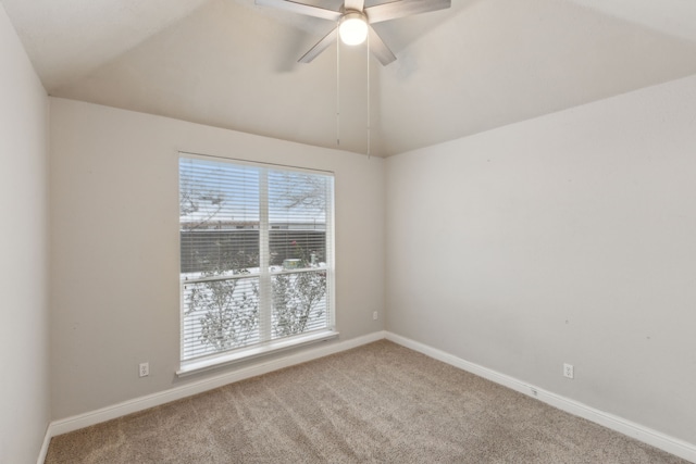 carpeted spare room with ceiling fan and vaulted ceiling