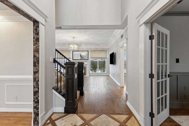 entryway featuring an inviting chandelier and crown molding