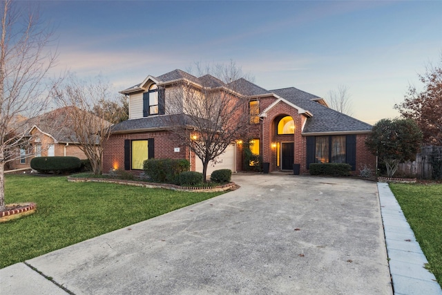 view of front property featuring a garage and a yard