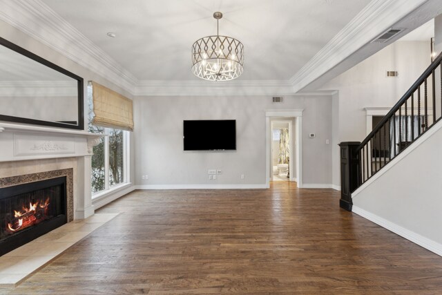 unfurnished living room featuring hardwood / wood-style flooring, a notable chandelier, and ornamental molding